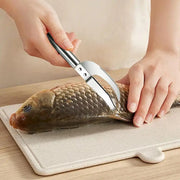 Person using a fish scaler on a fish 